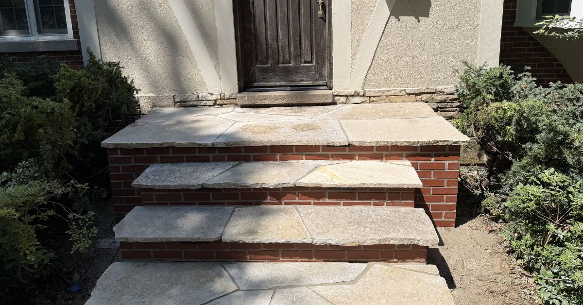 Hardscape renovation in Niles, IL with flagstone stairs, paver restoration, retaining wall cleaning, and stair lighting installation.