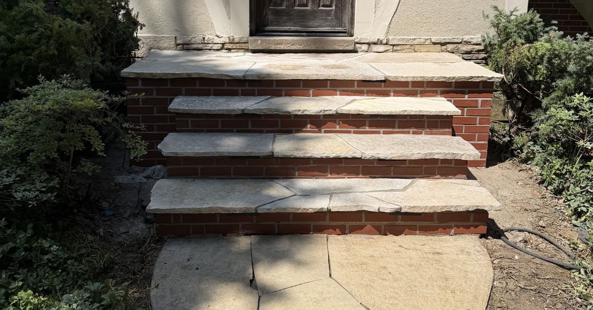 Hardscape renovation in Niles, IL with flagstone stairs, paver restoration, retaining wall cleaning, and stair lighting installation.