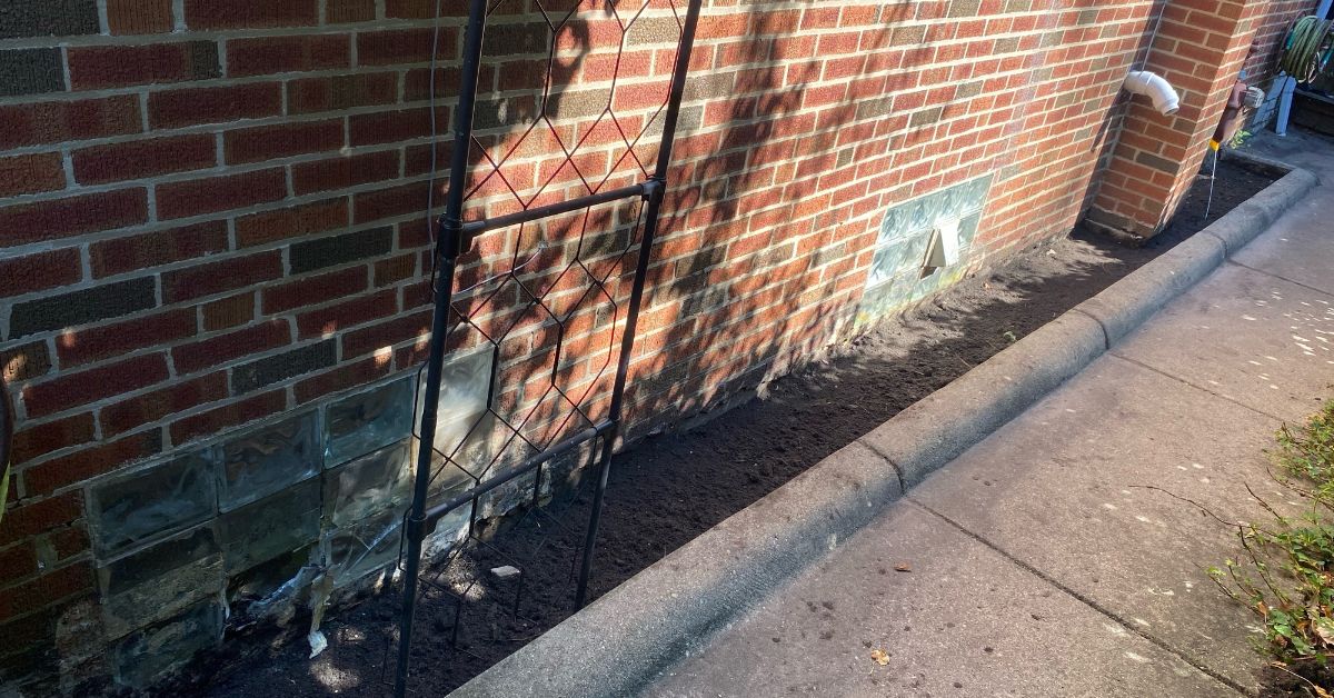 Residential foundation grading project in Highland Park, IL addressing water accumulation between the home and existing concrete walkway.