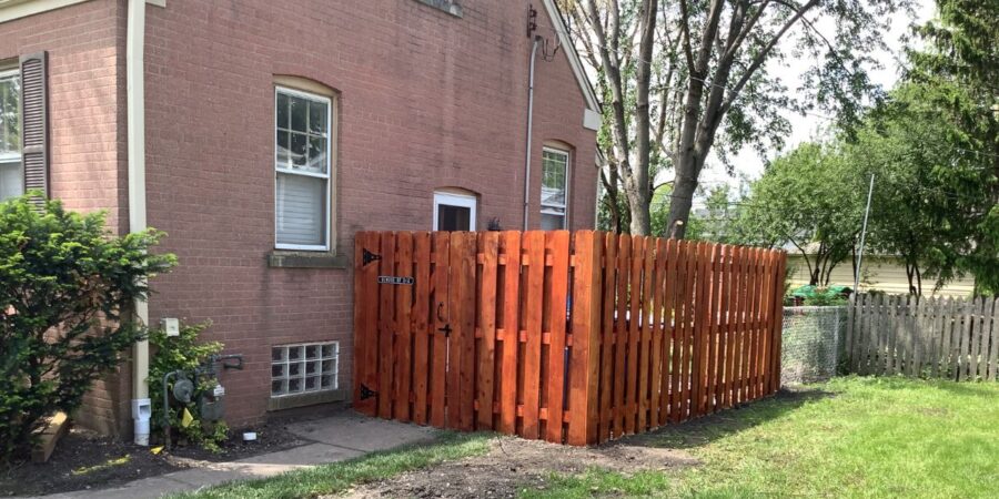 Backyard drainage and landscape renovation project in Niles featuring underground PVC drainage installation, grading improvements, lawn restoration, and a new board-on-board fence.