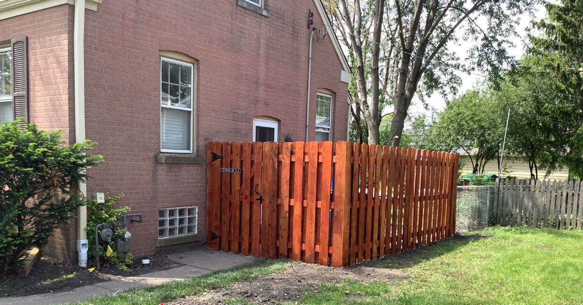Backyard drainage and landscape renovation project in Niles featuring underground PVC drainage installation, grading improvements, lawn restoration, and a new board-on-board fence.
