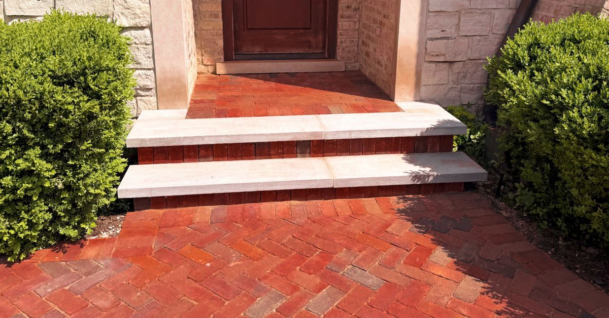 Finished asphalt driveway, clay paver accents, concrete front steps, and Indiana Limestone entrance renovation in Northbrook Illinois