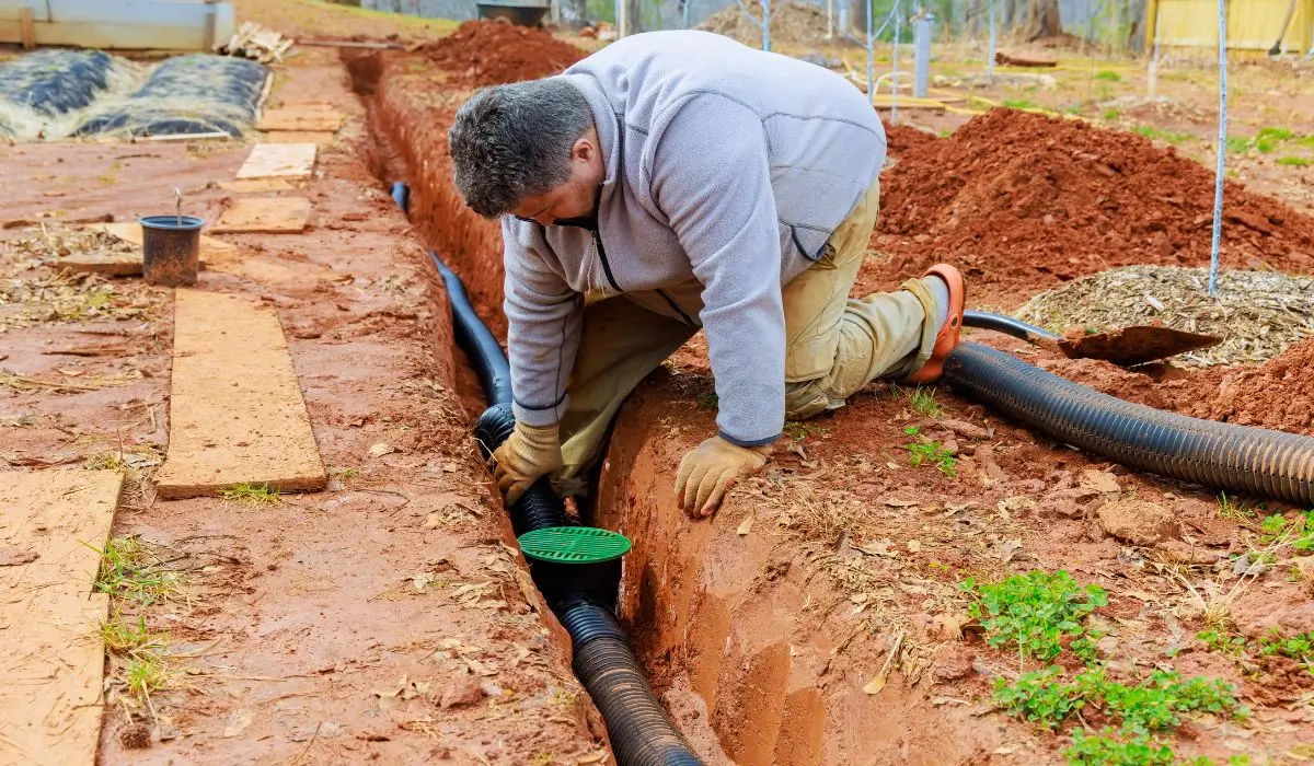 Technician installing a French drain system in Glenview yard.