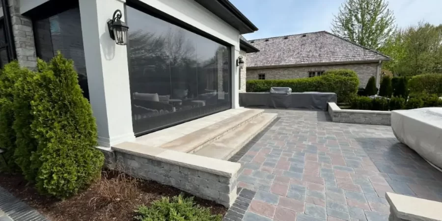 Stone patio with steps and retaining walls designed for late-summer hardscape installation in Park Ridge home.