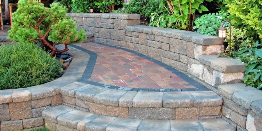 Brick and stone hardscape materials with steps and wall in Wilmette backyard.