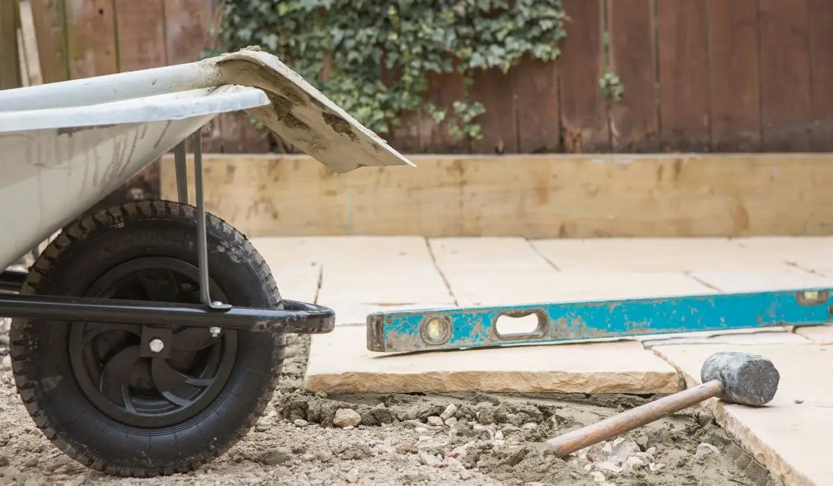 Hardscape material installation with grading and compaction tools in Wilmette yard.
