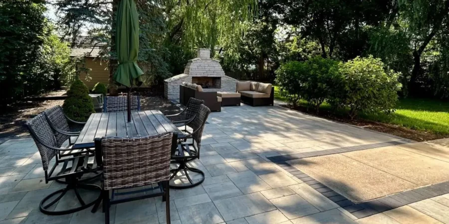 Modern backyard landscape design ideas featuring paver patio, built-in seating, fire feature, and mature greenery