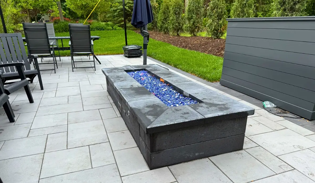 Built-In Fire Features on a stone patio in Glencoe with gas flames and glass stones for modern outdoor entertaining.