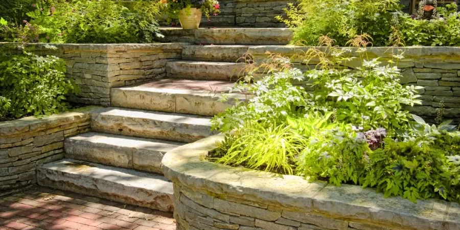Multi-Level Hardscape Designs with stone retaining walls, custom stairs, and lush greenery in a Glenview backyard.