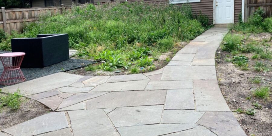 Park Ridge backyard with Unilock walkway, hardwood mulch, and diverse perennials including grasses, salvia, and allium