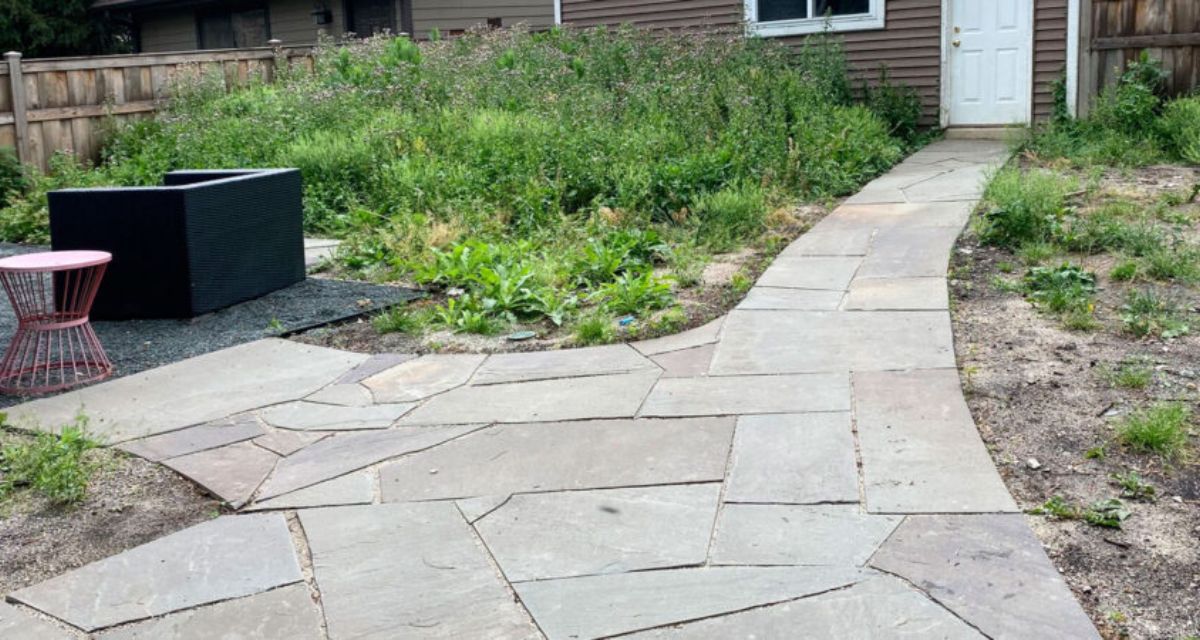 Park Ridge backyard with Unilock walkway, hardwood mulch, and diverse perennials including grasses, salvia, and allium