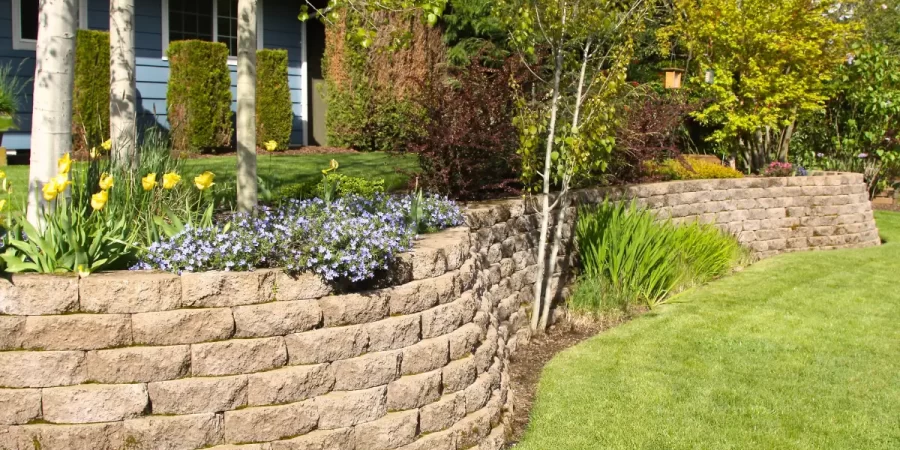 Retaining Wall Designs in Kenilworth showcasing a stone block wall with slope stabilization and garden landscaping.