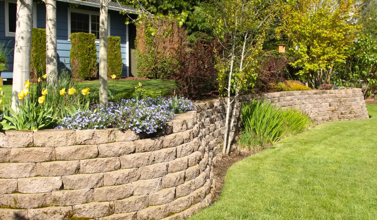 Retaining Wall Designs in Kenilworth showcasing a stone block wall with slope stabilization and garden landscaping.