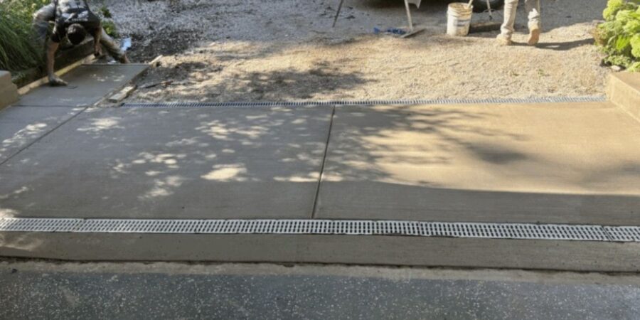 Riverwoods NDS drainage upgrade with new driveway, channel drains and rebuilt lines preventing garage and yard floods.