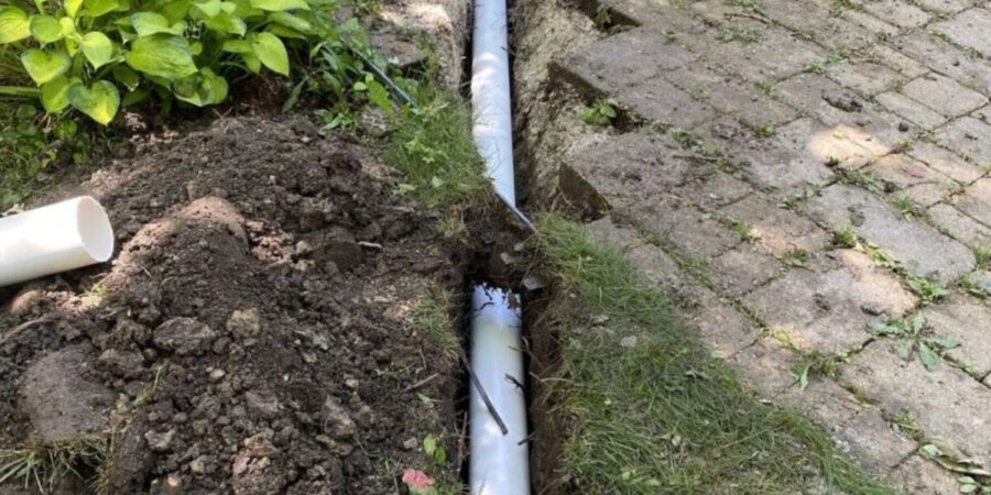 Riverwoods asphalt driveway and custom drainage system with pavers, catch basins, and landscape water management.