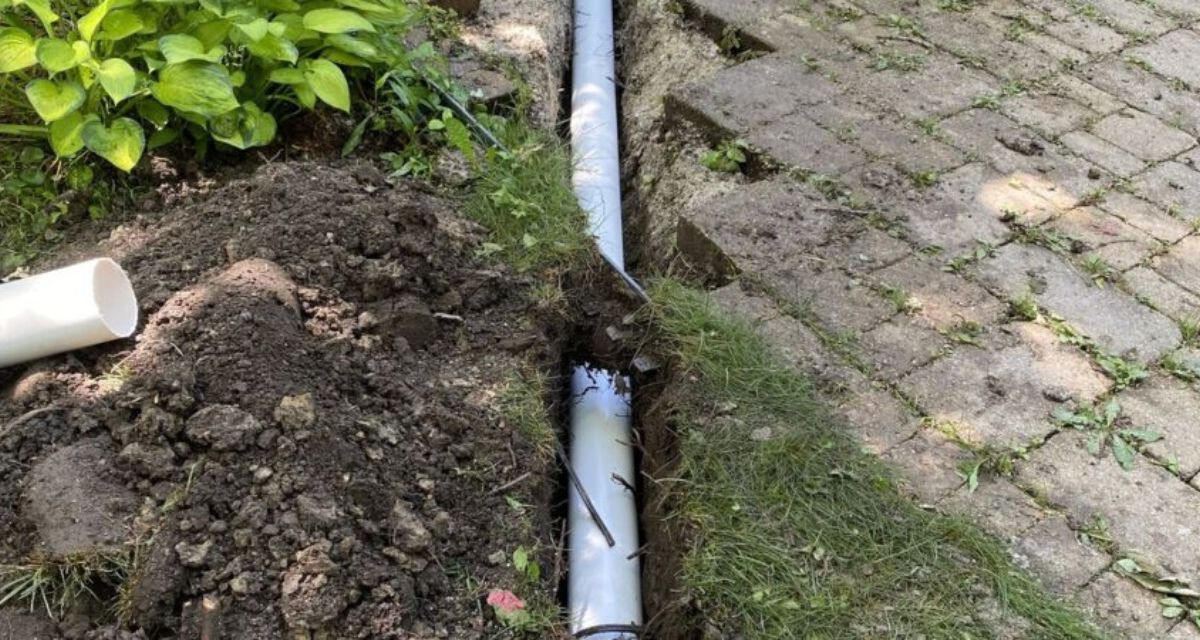 Riverwoods asphalt driveway and custom drainage system with pavers, catch basins, and landscape water management.