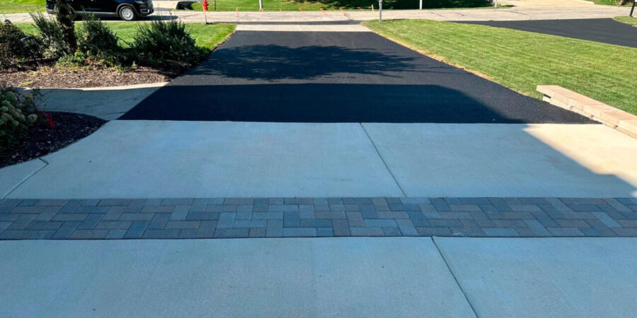 Schaumburg driveway reconstruction with asphalt, concrete, Unilock brick borders, retaining wall and Geo Grid.