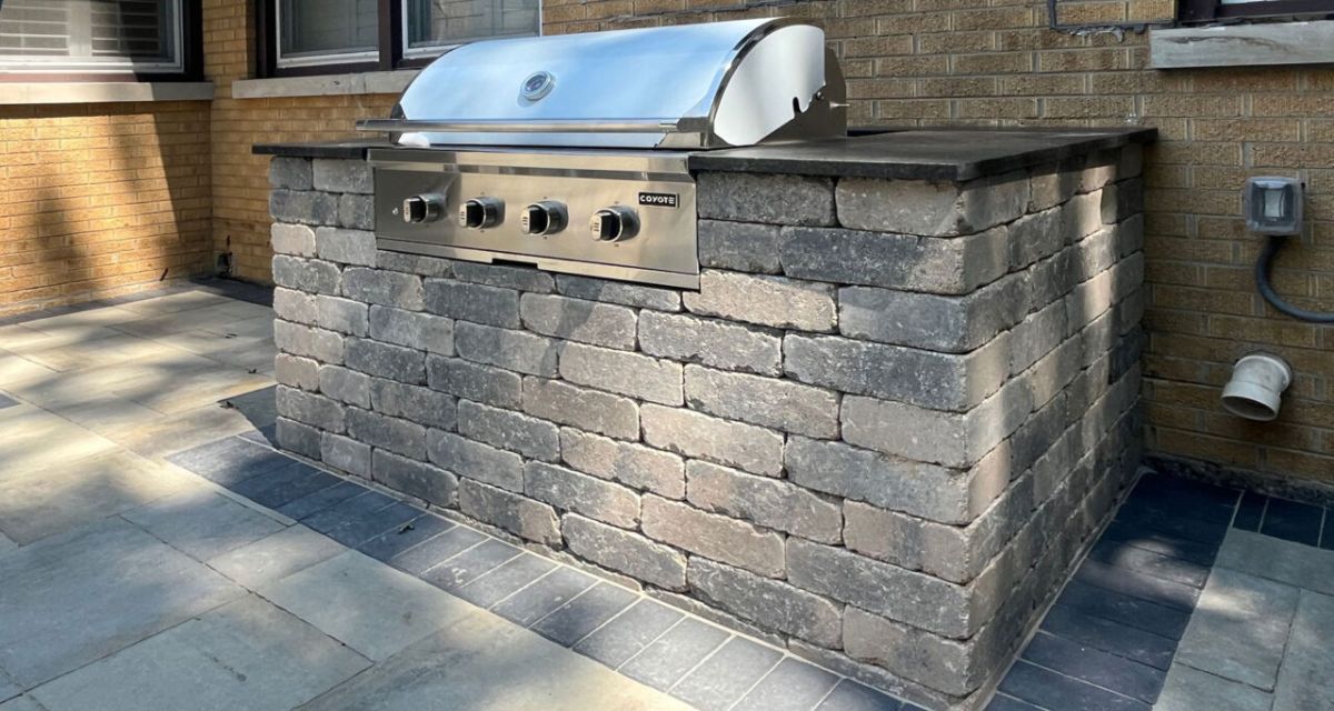 Winnetka backyard with new Bristol Valley pavers, charcoal border, rebuilt grill island, and limestone steps installed