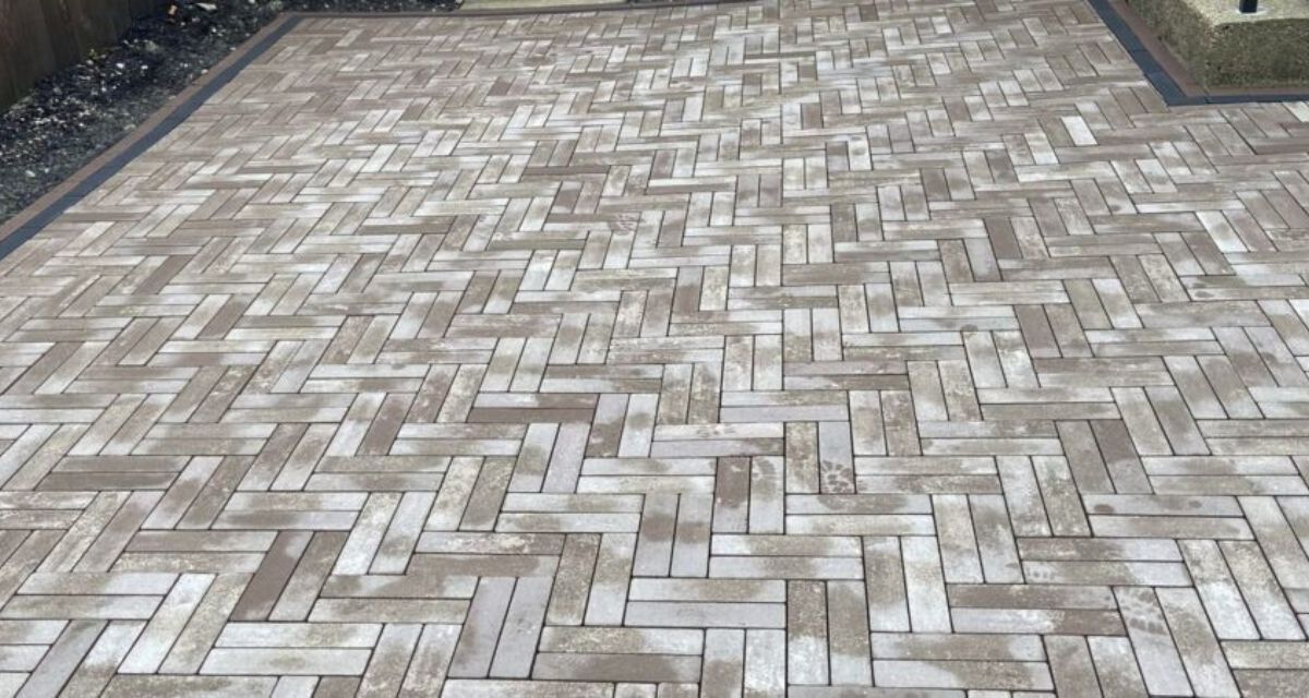 Wilmette hardscape renovation featuring Unilock pavers, rebuilt front stoop, custom iron railings, and buried drainage lines.