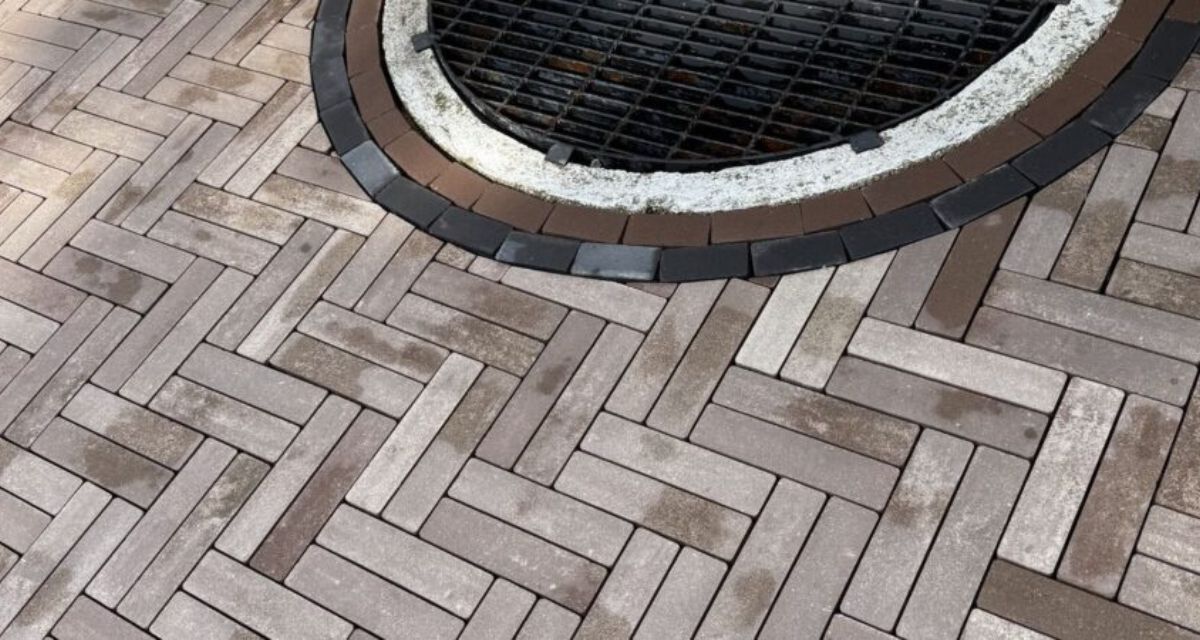 Wilmette hardscape renovation featuring Unilock pavers, rebuilt front stoop, custom iron railings, and buried drainage lines.