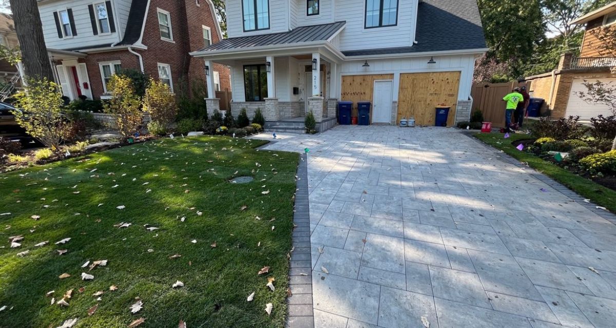Wilmette landscape featuring bluestone porch, Unilock pavers, new deck, sod, irrigation, and drainage improvements.